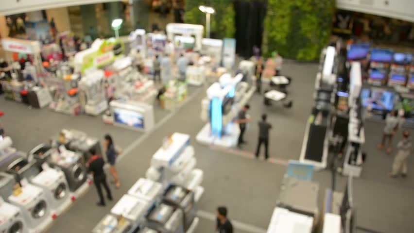 defocused crowd of walking people in the shopping mall center