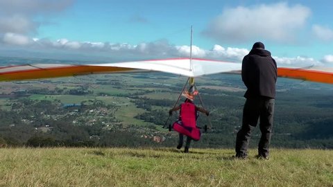 Hang gliders take off from mountain top