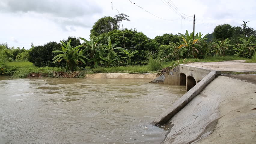 Raging River Floodwater Under a Bridge .