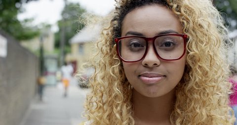 Close up portrait beautiful young mixed race woman smiling at camera urban scene : vidéo de stock