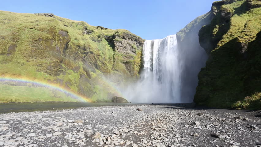 Iceland, Skogafoss waterfall during a beautiful summer day. Doble Rainbow and no people, the water falls over the green icelandic landscape, amazing scene. Wide angle