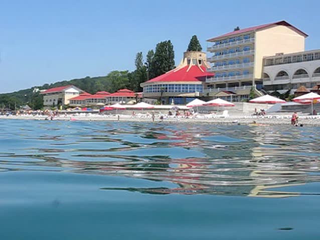 view of hotel from sea near beach with vacationer tourists 