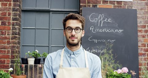Happy barista man portrait outside cafe : vidéo de stock