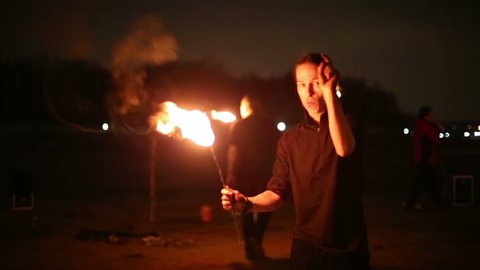 Boy counts down and makes fireball at fire show in evening.