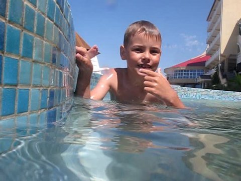 little boy closed his nose diving into swimming pool, underwater survey 