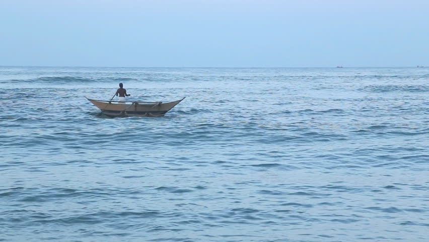 MIRISSA, SRI LANKA - MARCH 2014: Local fisherman in his boat in Mirissa. These traditional fishermen find it harder to make a living from poor fishing catches.