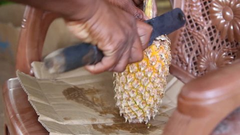 Close up view of a local man cutting pineapple, a very popular fruit which grows all around Sri Lanka.