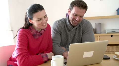 Couple Using Laptop At Home Together
