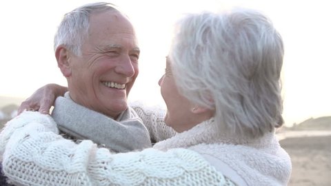 Romantic Senior Couple Embracing On Winter Beach In Slow Motion