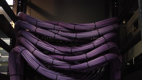 This high definition footage is of a video server cables. The camera pans slowly down to reveal a organized video cable structure in HDV format. Other formats available