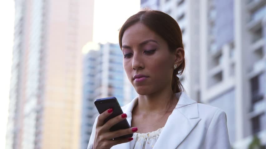 Business people, young hispanic woman with disappointed expression using mobile phone in city street, receiving bad news via email. 4of6 | Shutterstock HD Video #7391983