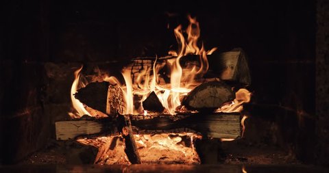 Slow motion of Fireplace burning. Warm cozy burning fire in a brick fireplace close up. Cozy background. Filmed at  120 fps 4k graded from RAW