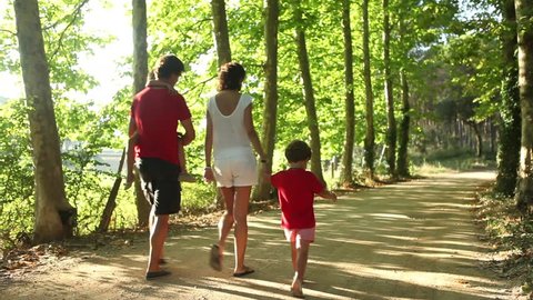 Happy young Family outdoors on a sunny day, tracking shot. 
