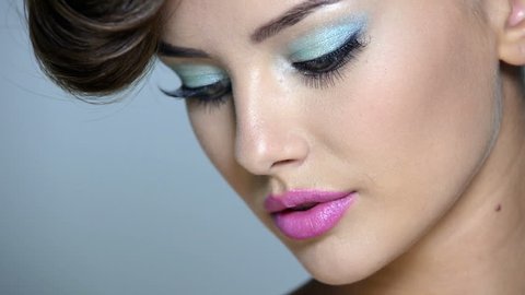 Closeup face of a beautiful  girl with blue eye makeup and pink lips. Full hd video footage  clip 1080.