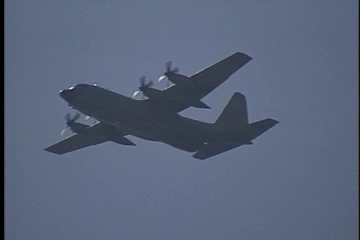 An Italian Air Force C-130 Flies overhead.