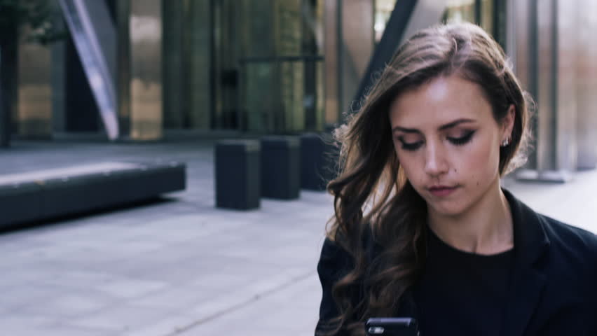 Attractive business woman commuter using smartphone walking in city of london - RED EPIC DRAGON 6K