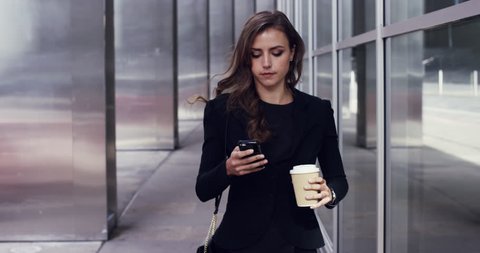 Attractive business woman commuter using smartphone walking in city of london - RED EPIC DRAGON 6K