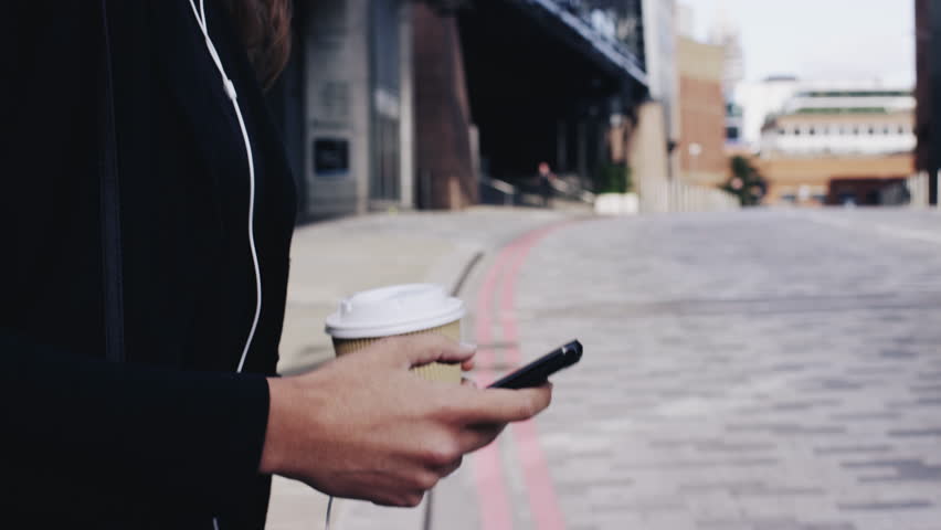 Attractive business woman commuter using smartphone walking in city of london - RED EPIC DRAGON 6K