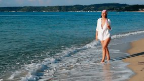 A young woman with bare feet walking on the sea beach, Enjoying the sea, Video clip