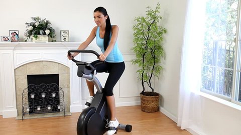 Woman exercising at home with a stationary bicycle.