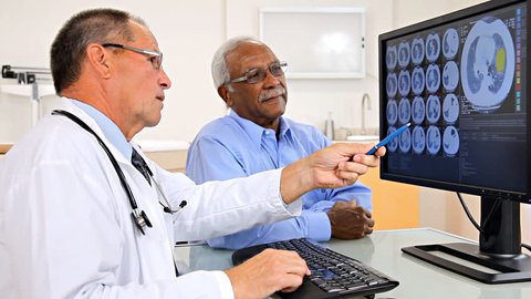Doctor reviewing an MRI scan on the computer with the patient.