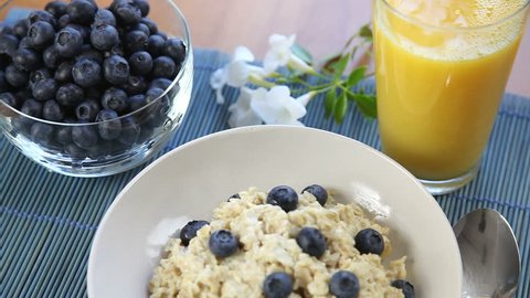 Healthy breakfast of oatmeal, blueberries, and orange juice.