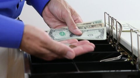Man dispensing change from a register cash drawer.