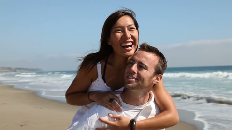 Young loving couple being playful on the beach.
