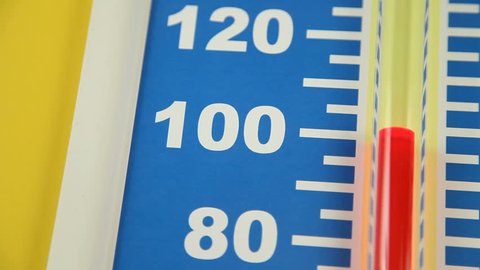 Close up of a Fahrenheit thermometer showing a rapid rise in temperature in the range of 80 to 120 degrees.