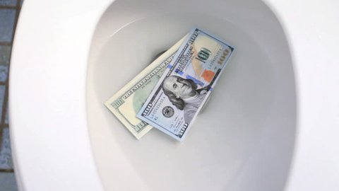 Cash flushing down toilet drain, wasting money concept 