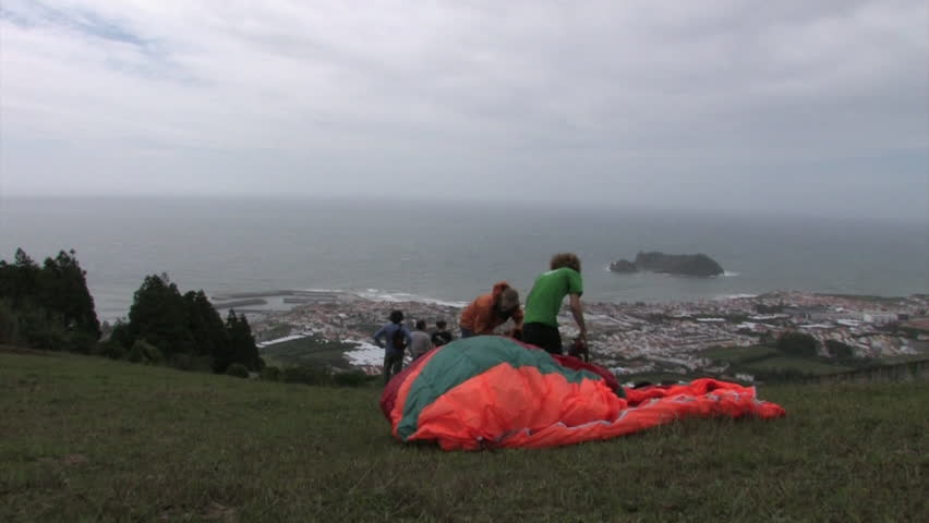 Two paragliders get their backpacks and wings ready | Shutterstock HD Video #7419337