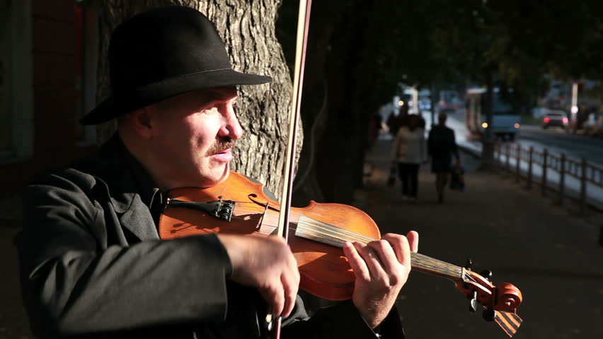 PETROZAVODSK, RUSSIA - SEPTEMBER 18, 2014: Street musician plays the violin in the city centre.  Street musician on the street of a provincial town. | Shutterstock HD Video #7429045