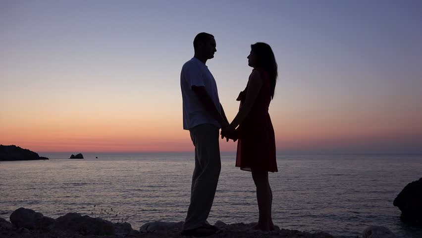 Он она закат море. Couple standing Evening. Couple holding hands. Couples hold Umbrellas in Sunny weather.