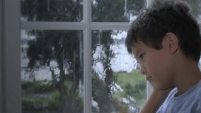4k child looking out rainy window, multiple angle sequence stock video clip