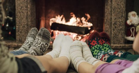 Feet in woolen socks warming by cozy fire in Christmas time in slow motion. Family with two kids warming their feet by the fireplace in winter time. Filmed at 120 fps 4k graded from RAW, videoclip de stoc
