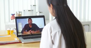 Asian doctor video chatting with African patient