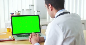 Mexican doctor talking to laptop with green screen