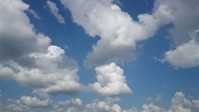 Time-Lapse white fluffy clouds over blue sky