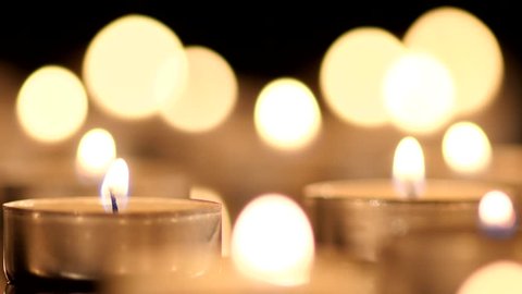 Many Candles light on black background.