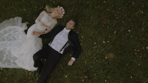 Attractive couple celebrate their wedding on the grass- aerial view Stock Video