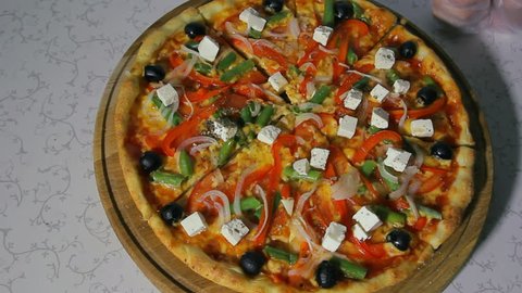 Pizzaiolo preparing a pizza for serving