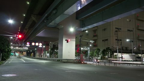 (Timelapse) Night commuters lights around the Rainbow Bridge entry ramp in Tokyo waterfront.