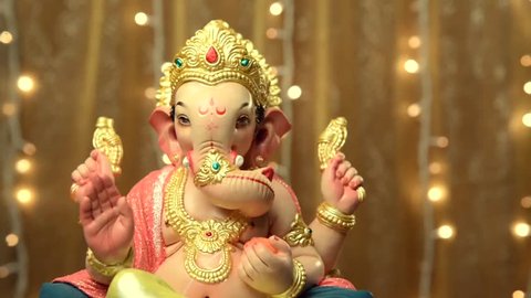 Ganesha- a statue of an Indian god against blinking christmas lights. Studio shot. Stockvideo