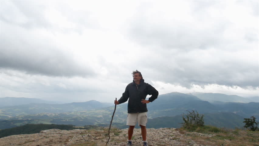 man standing at the top of a mountain