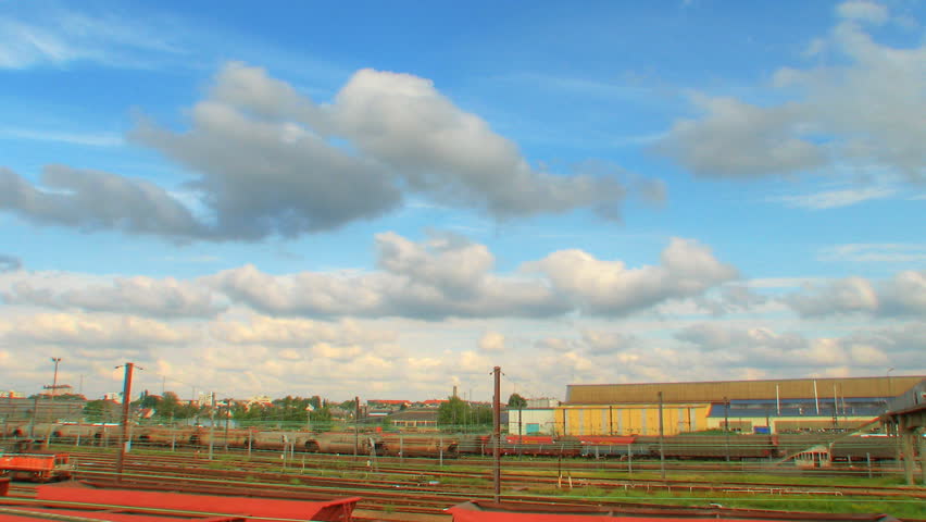 Clouds rolling over industrial train station, HD time lapse clip, high dynamic