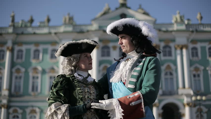 The first emperor of Russia Peter I hugs his beloved Catherine I against the background of the Winter Palace. Medium shot.