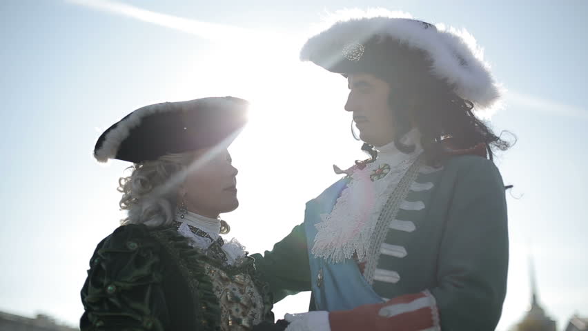 The first emperor of Russia Peter I hugs his beloved Catherine I against the background of the Winter Palace. Close up at sunset