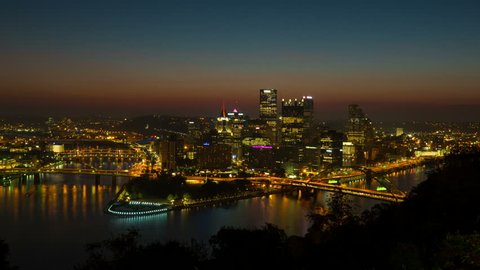 (Time-lapse/Zoom-in) Morning twilight transitions to sunrise over Pittsburgh, Pennsylvania including the skyline, bridges and Point State Park at the confluence of the Allegheny and Monongahela Rivers