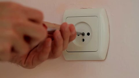 Electrician repairing a wall socket