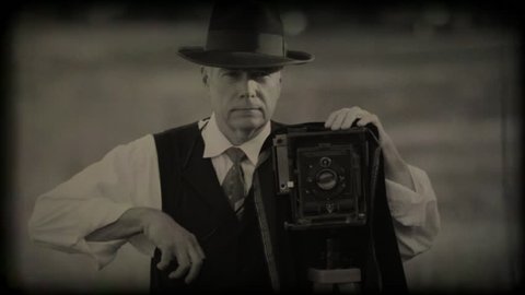 40s era photographer in a large open field taking photos with old film effect